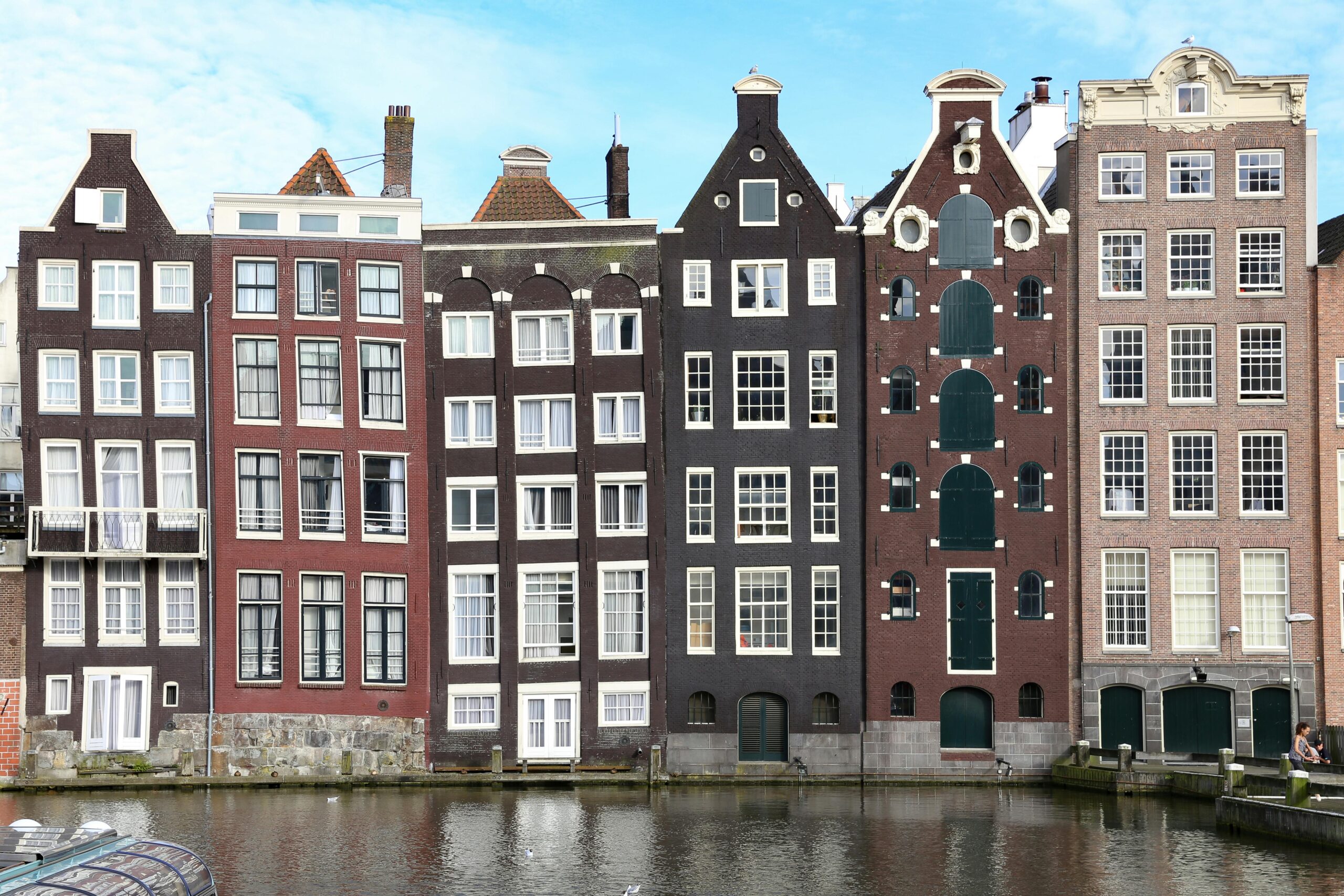 Scenic view of iconic narrow canal houses in Amsterdam showing unique architecture.